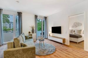 sala de estar con sofá, cama y espejo en Km Style Apartments 7 en Friburgo de Brisgovia