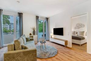 Una sala de estar con un sofá, una cama y un espejo. en Km Style Apartments 7, en Freiburg im Breisgau