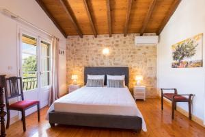 a bedroom with a large bed and two chairs at Grand Skylight in Corfu
