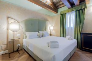 una camera da letto con un grande letto bianco e una finestra di 312 Piazza San Marco a Venezia