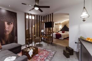 Utopia Luxury Suites - Old Town في بلدة رودس: غرفة معيشة مع أريكة وغرفة نوم