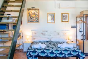 Schlafzimmer mit einem Bett mit blauer Bettdecke und Treppe in der Unterkunft Casa Ginevra - 3 Minutes Walk from the Sea in Livorno