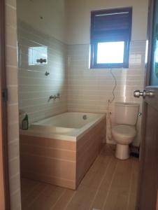 baño con bañera, aseo y ventana en Prasanna Homes, en Matara