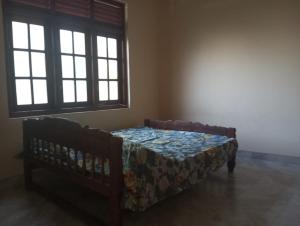 1 dormitorio con 1 cama y un banco en una habitación en Prasanna Homes, en Matara