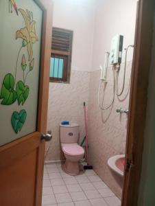 baño con aseo rosa y lavamanos en Prasanna Homes, en Matara