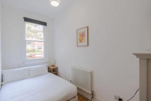 ロンドンにあるThe Oval Abodeの白いベッドルーム(ベッド1台、窓付)