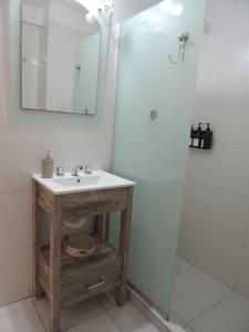 a bathroom with a sink and a shower with a mirror at Tu alquiler Resistencia in Resistencia