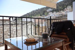 een tafel met een bord brood en een kopje koffie op een balkon bij FOTEINI RESIDENCE in Kalymnos