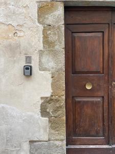 een houten deur aan de zijkant van een stenen muur bij L'Angoletto Home to Stay in Sansepolcro
