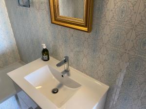La salle de bains est pourvue d'un lavabo blanc et d'une bouteille de savon. dans l'établissement Miramar8, à Bastia