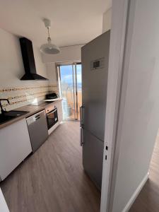Il comprend une cuisine équipée d'un réfrigérateur en acier inoxydable et une fenêtre. dans l'établissement Miramar8, à Bastia