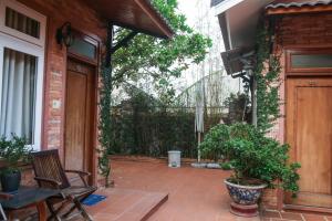 eine Terrasse mit einem Tisch, Stühlen und einem Zaun in der Unterkunft Villa Tuấn Phạm in Da Lat