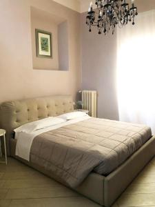 a bedroom with a large bed with a chandelier at Allegra Toscana - Affittacamere Guest house in Arezzo