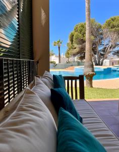 a bed with blue pillows sitting next to a pool at GM House Minorca in Cala en Bosc