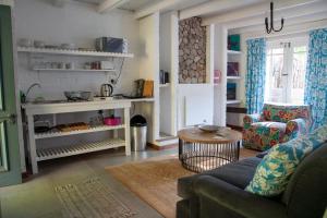 a living room with a couch and a table at Old Potters Inn in Greyton