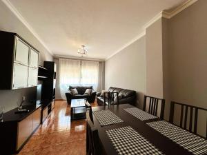 un salon avec une table et un canapé dans l'établissement BAJBAJ - Apartamento 2 dormitorios a 100 metros de la Playa del Bajondillo, a 300 metros del centro de Torremolinos, à Torremolinos