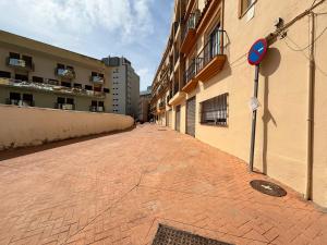 une rue en briques vide à côté d'un bâtiment dans l'établissement BAJBAJ - Apartamento 2 dormitorios a 100 metros de la Playa del Bajondillo, a 300 metros del centro de Torremolinos, à Torremolinos