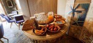 カロ・リヴァディにあるMykonian Iros Suites & Villasのフルーツとドリンクを盛り付けたテーブル