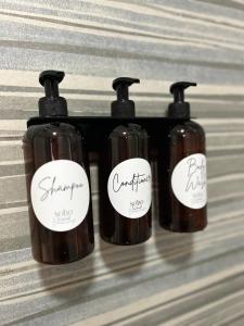 a group of four bottles of soap with labels on them at Soho Ayvalık Beach House in Kucukkoy