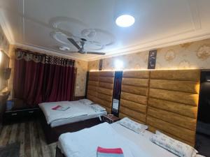 a room with two beds and a ceiling at Valley holidays in Srinagar