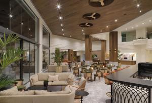 a lobby with couches and tables and a bar at GrandResort by Leonardo Hotels in Limassol