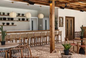 un restaurante con mesas y sillas y un bar en GrandResort by Leonardo Hotels, en Limassol