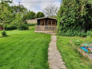 une petite maison dans une cour avec une pelouse dans l'établissement The Cabin - a very quiet location, à Pewsey