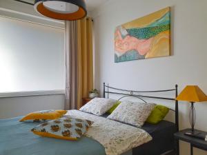 a bedroom with a bed and a painting on the wall at Apartment with Terrace Nona Pavla in Tolmin