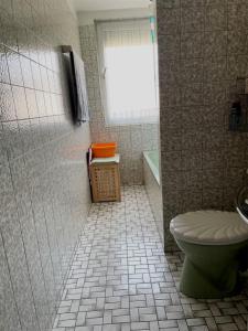 uma casa de banho com um WC, uma janela e uma banheira em Schöne 3-Zimmer-Wohnung nahe Düsseldorf Flughafen und Messe em Duisburg