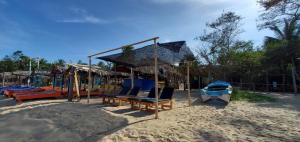 a playground with chairs and a swing set on the beach at Surf And Stay Arugam Bay in Arugam Bay