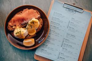 a plate of food on a table next to a menu at PH Hostel Manchester NQ1 in Manchester