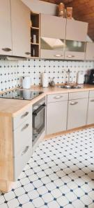 a kitchen with white cabinets and blue and white tiled floors at Ferienwohnung Funk in Müllenbach