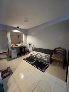 - un salon avec un lit et un bureau dans l'établissement Butuan Cozy Riverhouse Transient, à Butuan