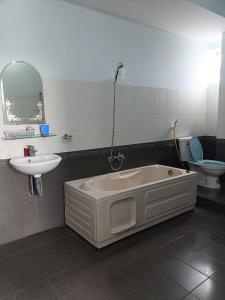 a bathroom with a tub and a sink and a toilet at Nhà nghỉ thảo ngân in Bình Mỹ