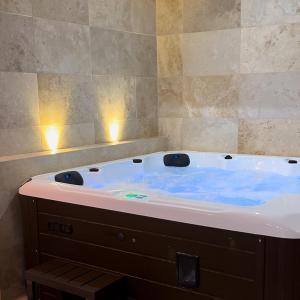 uma banheira com água azul num quarto em La nuit de rêve Suite privative Jaccuzi Sauna Suite 2 em Crouy