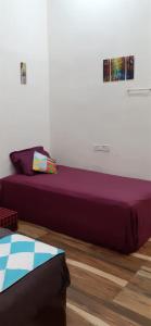 孟買的住宿－Sequence Villa，一张位于带紫色床罩的房间内的床铺