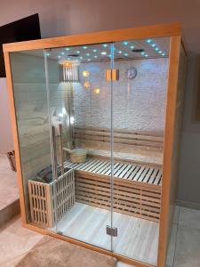um compartimento de vidro com um chuveiro num quarto em La nuit de rêve Suite privative Jaccuzi Sauna Suite 2 em Crouy