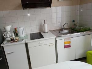 uma pequena cozinha com armários brancos e um lavatório em Studio Danton em Troyes