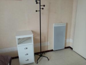 a room with a dresser and a pole in the corner at Studio Danton in Troyes