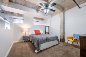 堪薩斯城的住宿－3BR 2BA Luxury Historic Loft With Gym by ENVITAE，一间卧室配有一张床和吊扇