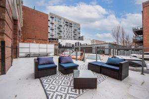 a patio with two chairs and a table and a building at 3BR 2BA Luxury Historic Loft With Gym by ENVITAE in Kansas City