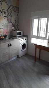 a kitchen with a washing machine and a microwave at La Oficina in Fernán Pérez
