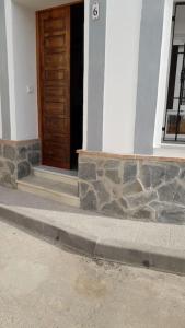 a front door of a house with a stone wall at La Oficina in Fernán Pérez