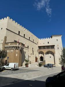 duży budynek z samochodami zaparkowanymi na parkingu w obiekcie Casa nella Fortezza w mieście Pitigliano