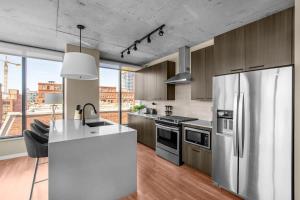 a kitchen with stainless steel appliances and a large window at 3BR Elegant Glass Penthouse Pool With Deck & Gym in Chicago