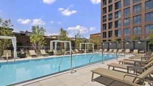 シカゴにある3BR Elegant Glass Penthouse Pool With Deck & Gymの大きなスイミングプール(椅子付)と建物