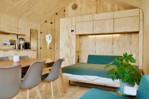 Cette chambre comprend un lit, une table et des chaises. dans l'établissement Wikkelboats at Floating Rotterdam Rijnhaven, à Rotterdam