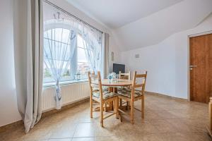 una sala da pranzo con tavolo, sedie e una finestra di Pensjonat Kwiatkowski apartament nr 3 a Nowęcin Altre 17 foto