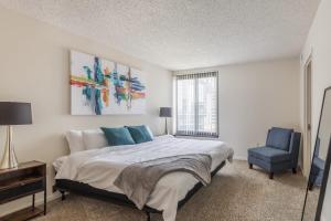 a bedroom with a bed and a blue chair at 2BR Executive Apartment with Balcony in Arlington