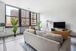 a living room with a couch and a large window at 2BR Premium Downtown Suite in Detroit